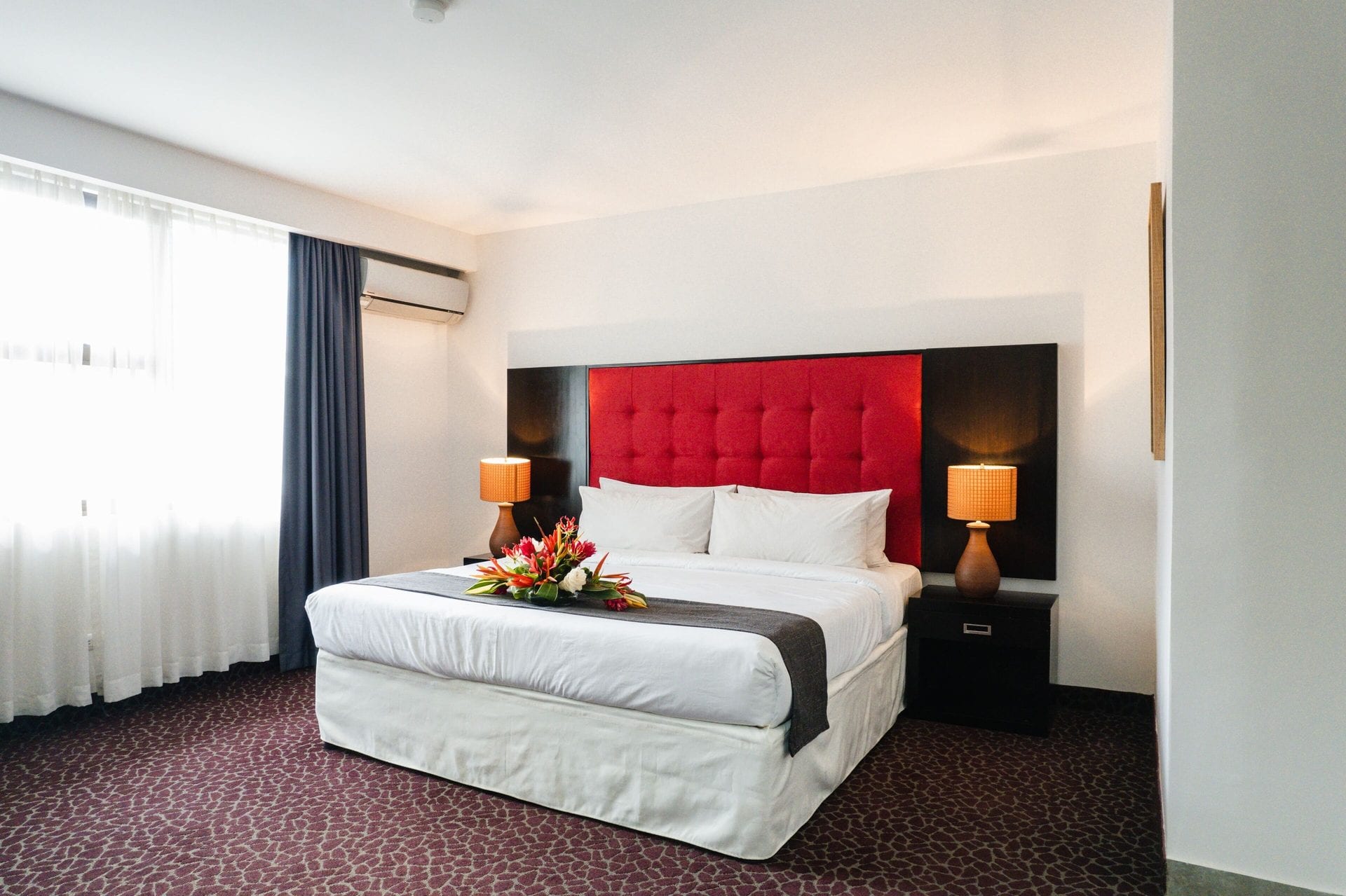 Junior Suite King de KC Hotel San José, con cama amplia y cabecero tapizado