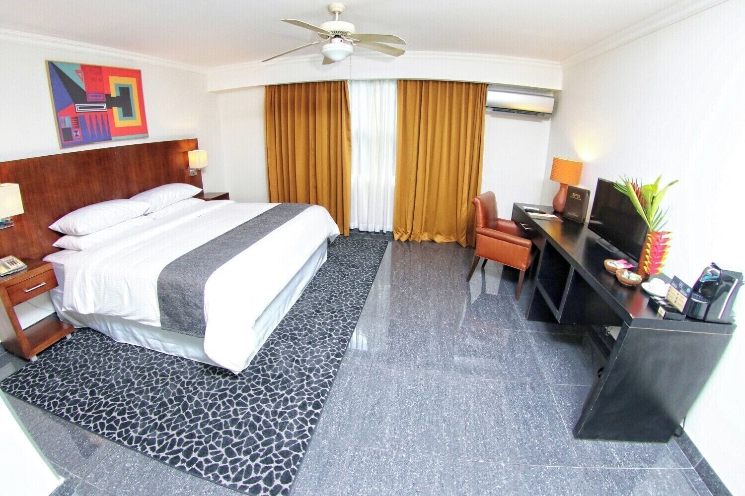 Habitación Superior King con cama king, ventilador de techo, escritorio con cafetera y sillón de cuero