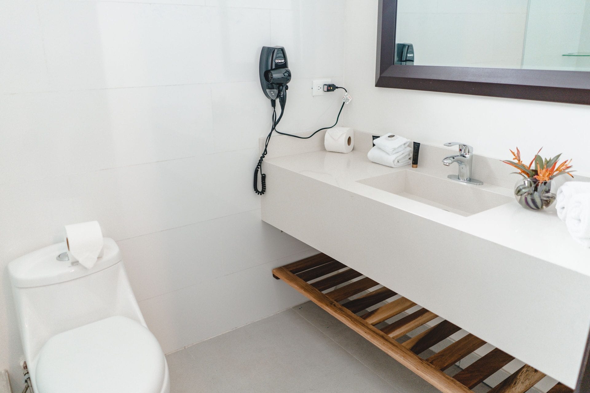 Baño del Apartamento Familiar con lavamanos de piedra, espejo, secador de pelo y toallas dobladas